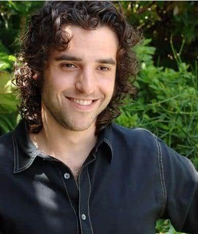 Photo of David Krumholtz long curly hairstyle.