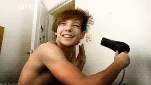 Photo of Louis Tomlinson blow-drying his hair.