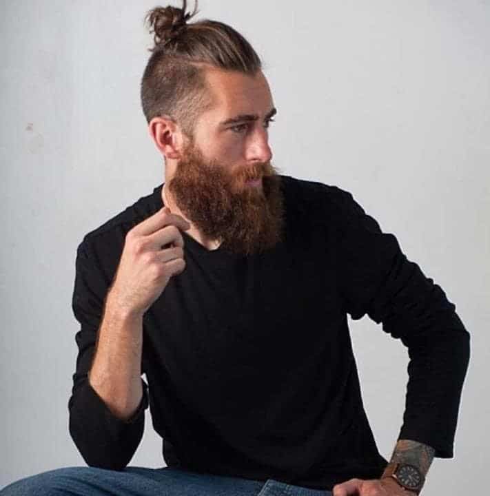 guy posing with a messy top knot bun