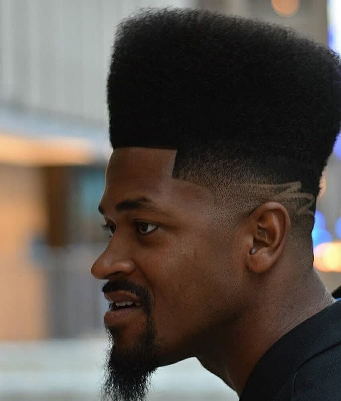 black guy with curly high top fade