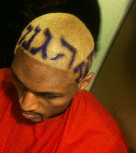 Photo of Ron Artest hairstyle with the letter Defense in Hebrew, Japanese, and Hindi.